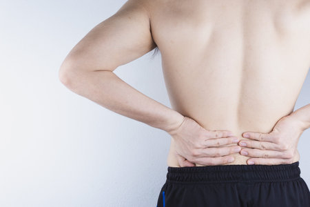 Closeup man suffering from lower back pain. Health care and medical concept.