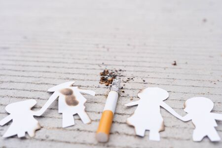 Paper cut of family members destroyed by cigarette. Smoking destroying family concept. Quit smoking for life on world tobacco day.の写真素材