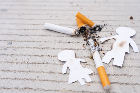 Paper cut of family members destroyed by cigarette. Smoking destroying family concept. Quit smoking...