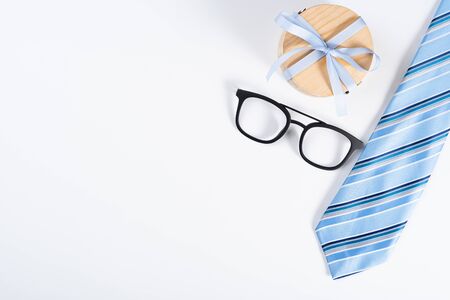 Happy Father Day background concept with blue necktie, glasses and gift box on white background with copy space for text.の写真素材