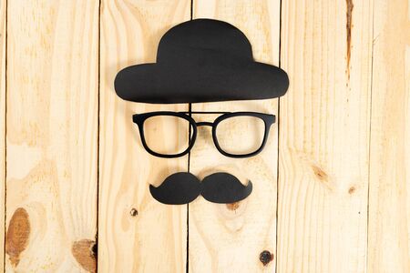 Happy Father Day background concept with glasses, black hat and black mustache on wooden background with copy space for text.の写真素材