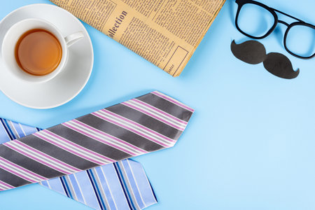Happy Father Day background concept with blue and pink necktie, glasses, newspaper, cup of tea and...