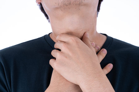 A man feeling exhausted and suffering from neck pain and injury on isolated white background. Health...