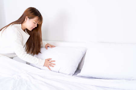 Beautiful Asian women making bed in room early in the morning. daily life concept.の写真素材