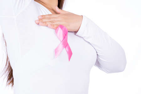 Breast cancer awareness ribbon on woman chest and doing self exam isolated over white background. Medical, healthcare for advertising concept.の写真素材