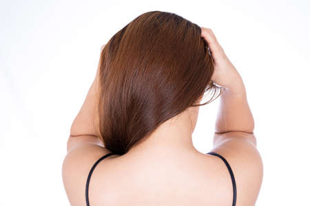 A woman feeling exhausted and suffering from neck and head pain and injury on isolated white background. Health care and medical concept.の写真素材