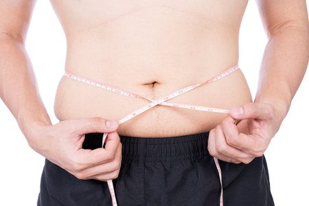 Chubby man measuring his waist with white measuring tape isolated on white background. Diet...