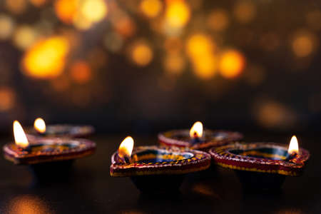 Indian festival Diwali, Diya oil lamps lit on colorful rangoli. Hindu traditional. Happy Deepavali. Copy space for text.の写真素材