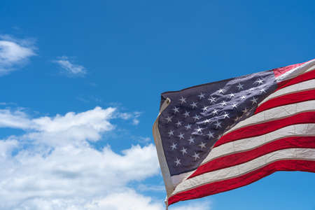 Waving USA flag under blue sky background.の写真素材