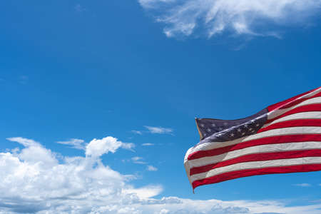 Waving USA flag under blue sky background.の写真素材