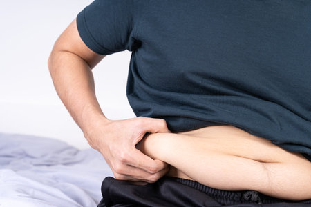 Fat man holding excessive fat belly, overweight fatty belly. Diet lifestyle, weight loss, stomach muscle, healthy concept.の写真素材