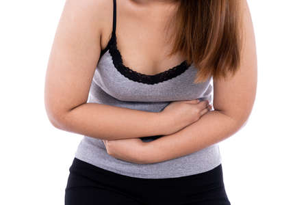 Woman suffering from stomach pain and injury isolated white background. Health care and medical concept.の写真素材