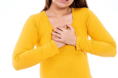 Woman touching her heart or chest isolated white background. Healthcare medical or daily life...