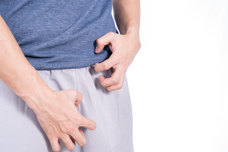 Man hands scratching his crotch isolated white background. Medical, healthcare for advertising...