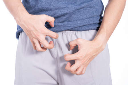 Man hands scratching his crotch isolated white background. Medical, healthcare for advertising concept.の写真素材