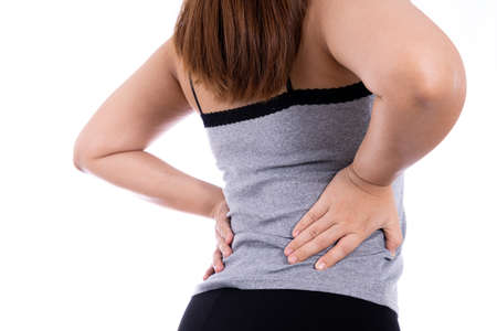Woman suffering from waist and back pain isolated white background. Health care and medical concept.の写真素材