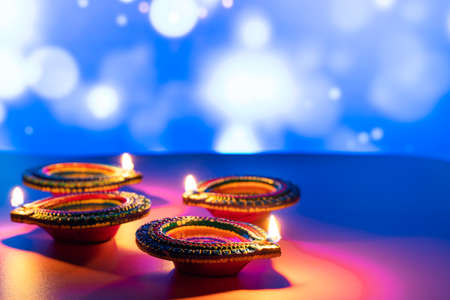 Indian festival Diwali, Diya oil lamps lit on colorful rangoli. Hindu traditional. Happy Deepavali. Copy space for text.の写真素材