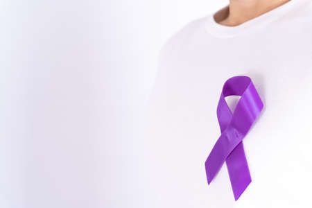 World cancer day, purple ribbon on chest isolated grey background. Healthcare and medical concept.の写真素材