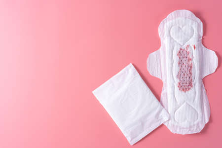 Used Sanitary pad with medium amount of blood, Sanitary napkin on pink background. Menstruation, Feminine hygiene, top view.の写真素材