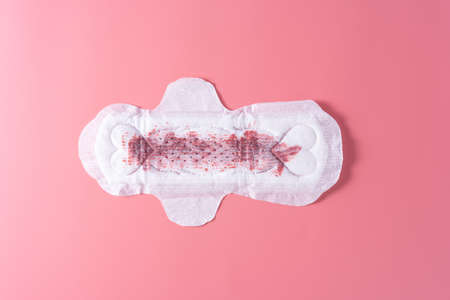 Used Sanitary pad with full amount of blood, Sanitary napkin on pink background. Menstruation, Feminine hygiene, top view.の写真素材