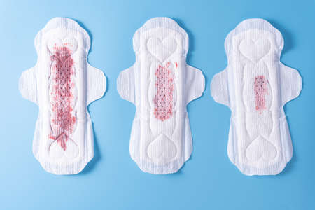 Set of different used sanitary pad, Sanitary napkin on blue background. Menstruation, Feminine hygiene, top view.の写真素材