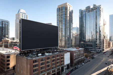 A large black billboard stands tall against a city skyline.の素材