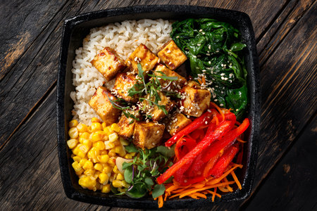 Vegan tofu rice bowl with colorful vegetables served in a dish.の素材