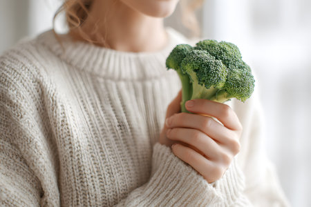 A vegan person holds fresh broccoliの素材