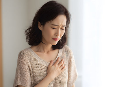Woman clutches chest feeling pain and discomfort.の素材