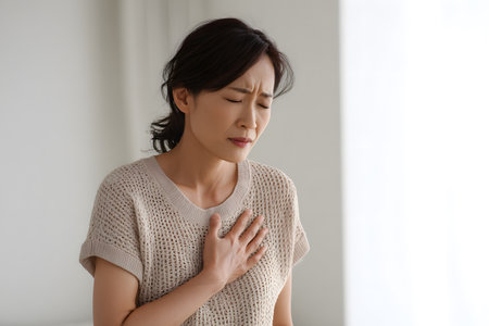 Woman feels pain in chest with hand over heartの素材