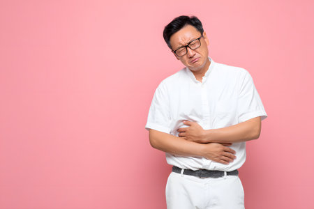 Man holding stomach in painの素材