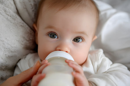 A baby drinks from a bottle while resting.の素材