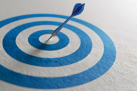 A blue dart pierces the center of a circular target.の素材
