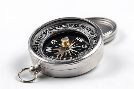 A silver compass is shown with its lid slightly open on a white background.の素材
