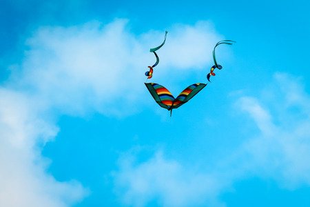 Kite flying in a bright blue skyの写真素材