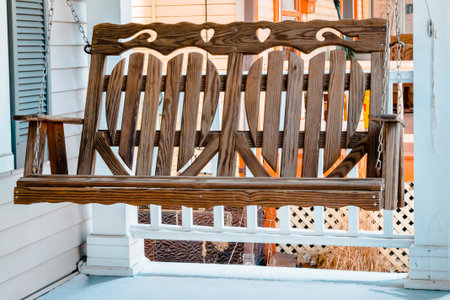 Wooden porch swing hanging during a spring dayの写真素材