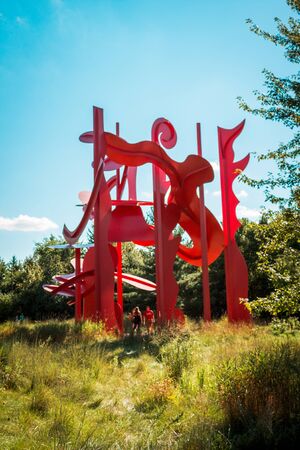 Huge red statue towering over a field in Grand Rapids Michiganの写真素材