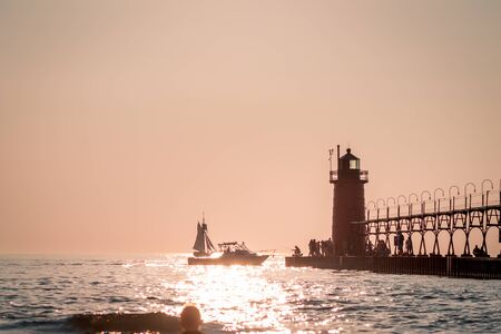 tourist and boaters near South Havens lighthouse at sunsetの写真素材