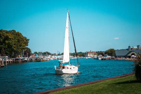 small sailboat returning to harbor in South Haven Michiganのeditorial素材
