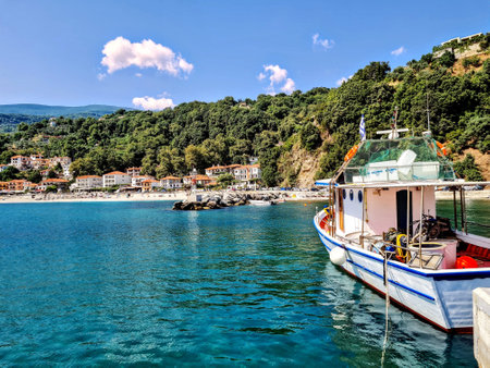 A view of the seaside town of Agios Ioannis taken from the rocky pier. A boast is visible.の写真素材