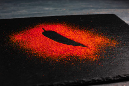 Red chili pepper silhoutte on black slate board.の写真素材