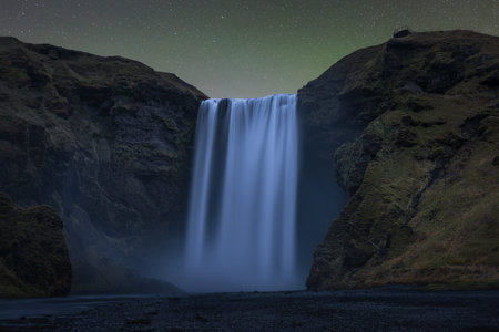 Aurora glow over Skogafoss at nightの写真素材