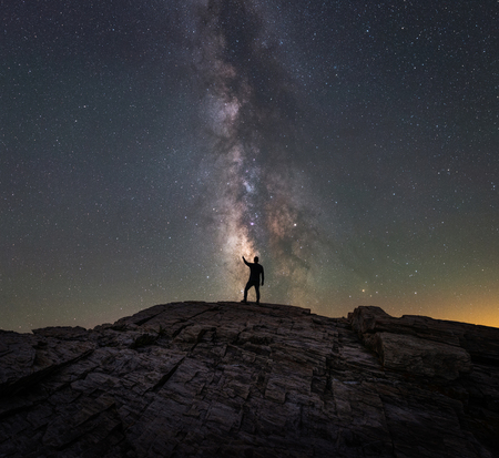 Silhouette of a man point to the stars in the milky way galaxyの写真素材