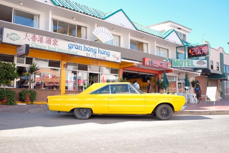 Typical Mexican scene of old classic car parked outside a cheap motel and taco stand.のeditorial素材