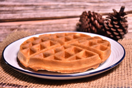 Waffles on a plate on a wooden background. Selective focus.の写真素材