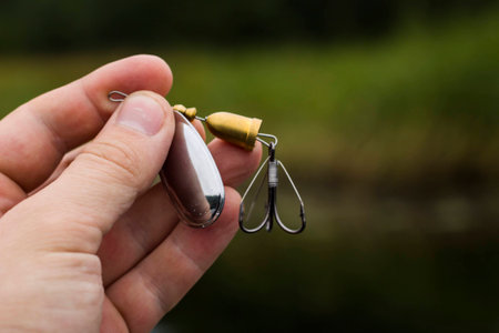 spinner with a triple hook for fishing in the handの写真素材