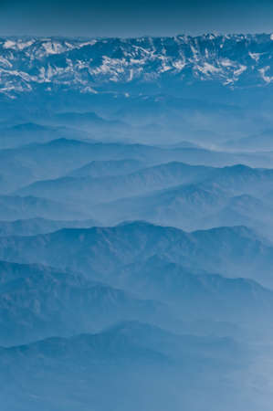 View from the height of the Himalayan mountains from an airplane in the early morning, a landscape in blue colors.blue mountains and foothills under us.の写真素材