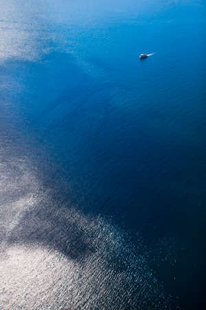 A small ship among the truncated blue sea, a view from a height. Photos from the paragliderの写真素材