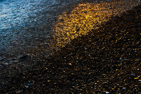 Golden sand, consecrated by the setting sun, by the sea, wet from the ebbing wave. Texture