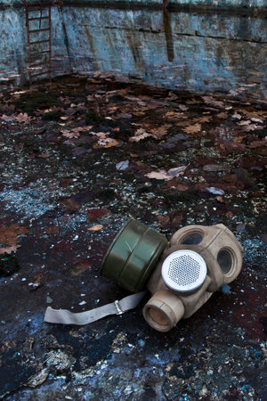 An old gas mask lies among dead foliage, a symbol of the horrors of nuclear war and chemical weapons...